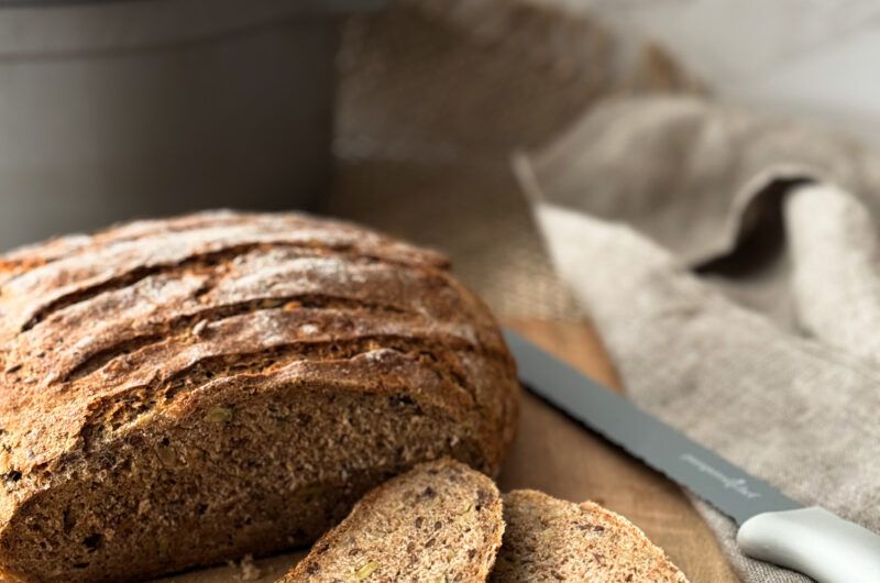 木板上摆放的全麦面包、豆类和浆果